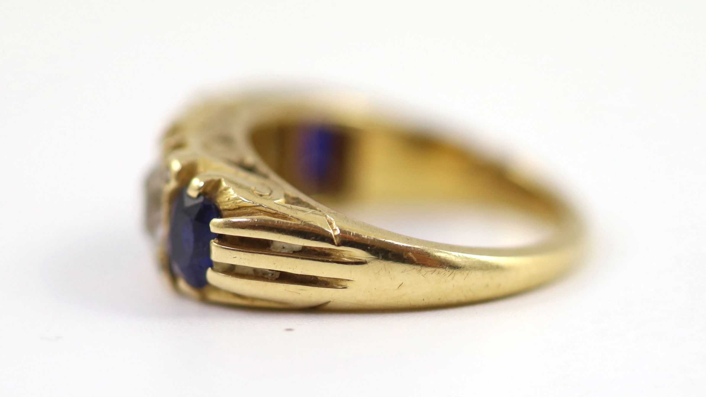 An early 20th century 18ct gold, three stone sapphire and two stone diamond set half hoop ring